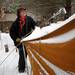 Resident Paul Harris clears a few inches of snow of the roof of another resident's tent  to keep it from collapsing at Camp Take Notice on Tuesday. Melanie Maxwell I AnnArbor.com